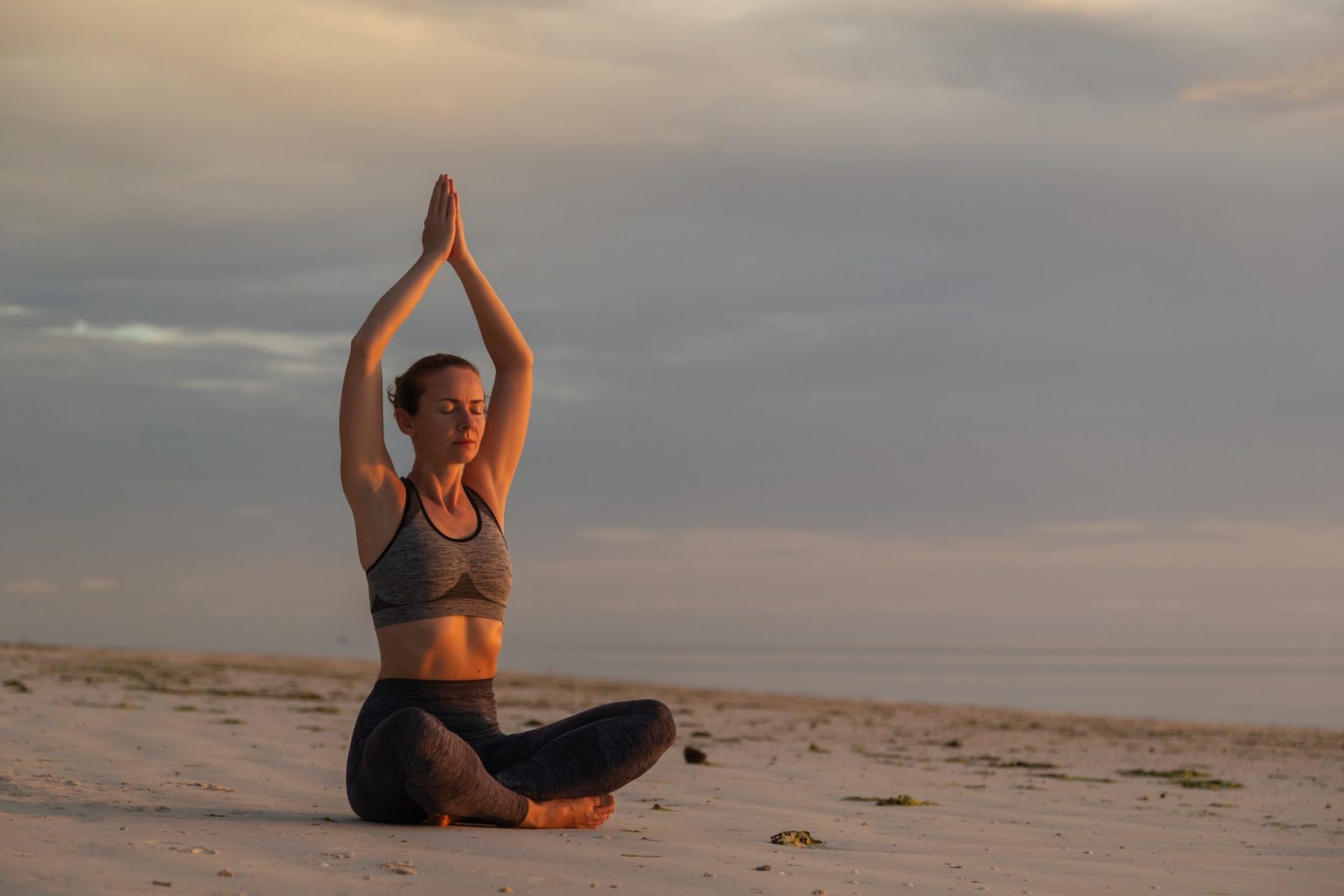 woman-practising-yoga-on-the-beach